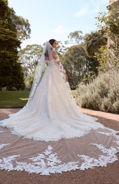 A-Linien Brautkleid mit abnehmbaren Off-Shoulder-Trägern, floraler Spitze und ausgedehnter Schleppe in eleganter Gartenkulisse – FM Braut- und Abendmode Sandkrug bei Oldenburg.