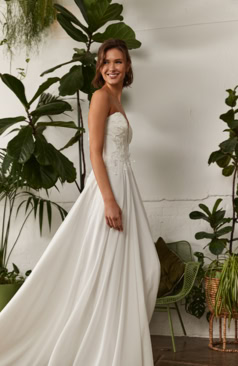 Modernes Brautkleid FM52075 mit schulterfreiem Spitzen-Corsagenoberteil und fließendem Satinrock – ein eleganter, femininer Look für stilvolle Bräute. Erhältlich bei FM Braut- und Abendmode in Sandkrug bei Oldenburg.