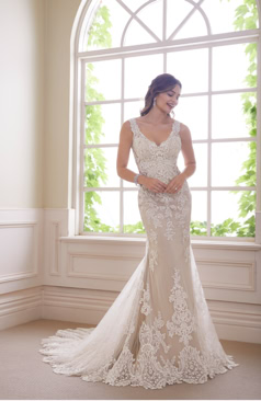 Ein wundervolles Fit and Flare Brautkleid mit markanter Spitze verziert. Das Brautkleid hat einen eleganten V- Ausschnitt sowie einen tief geschnittenen Rücken aus Tattoo-Spitze. An dem verführerischen Rücken befindet sich eine Knopfleiste. Das Fit and Flair Brautkleid hat zugleich elegante Beinschlitze an den Seiten des Kleides und eine stilvolle Tüll-Schleppe. 