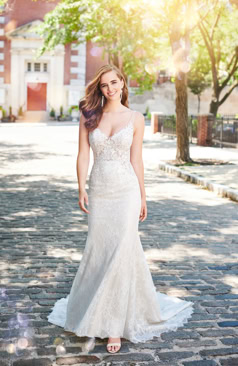 Ein schmeichelndes A-Linien- Spitzenkleid mit einem eleganten V- Ausschnitt. Das Dekolleté des Kleides ist mit schimmernden Perlen verziert. Das zusehende halbtransparente Oberteil ist mit Spitzenapplikationen verziert. Ein Blickfang ist vor allem der wundervolle Schmetterlingsrücken, der diesen gekonnt in Szene setzt. In dem Chiffonrock findet sich die Spitze wieder, die wiederum auch mit funkelnden Pailletten bestickt ist. Der Schmetterlingsrücken wird durch eine feine Knopfleiste geschlossen und das Kleid im unteren Bereich des Rückens, durch einen dezenten Reißverschluss. 