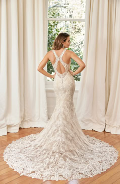 Ein modernes exklusives Fit-and-Flare Hochzeitskleid aus Allover-Spitze. Die Robe verfügt über Spitzenträger, einen wundervollen V- Ausschnitt und wird vervollständigt durch einen faszinierenden „überkreuzen“ Rückenausschnitt. Der Rückenausschnitt und das Kleid werden mit einer Knopfleiste geschlossen. Zudem besitzt das Fit-and-Flair Kleid eine atemberaubende Schleppe aus Spitze mit einem Spitzenabschluss. Romantisch schön!