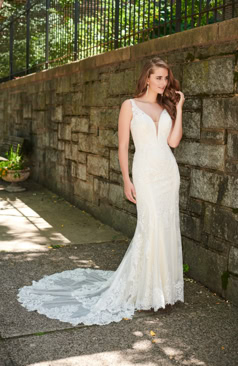 Hübsches A-Linien Kleid aus Spitze und Tüll mit einem eleganten niedrigem Rückenausschnitt. Zusehen ist ein geschwungener V- Ausschnitt und ein Illusionsspitzen-Rücken. Das Besondere an dem Kleid ist die All-Over Spitze die sich im gesamten Brautkleid wiederfindet. Auch ist ein wunderschöner markanter Spitzenabschluss zu erblicken. Der romantische Schnitt des Kleides betont vor allem die Figur. Das Kleid wird mit einer Knopfleiste im unteren Bereich des Rückens geschlossen.  