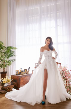 A-Linie Brautkleid mit abnehmbarem Überrock, figurbetonter Spitzen-Corsage und langen Spitzenärmeln, kombiniert mit modernem Schlitz – FM Braut- und Abendmode Sandkrug bei Oldenburg.