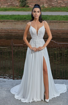 Modernes Brautkleid FM51714 mit tiefem V-Ausschnitt, zartem Spitzen-Corsagenoberteil und fließendem Chiffonrock mit Beinschlitz – feminin, elegant und perfekt für Sommerhochzeiten. Erhältlich bei FM Braut- und Abendmode in Sandkrug bei Oldenburg.