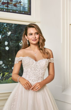 Ein wunderschönes Hochzeitskleid im Prinzessin Stil. Das hier zusehende Brautkleid verfügt über einen trägerlosen herzförmiges Ausschnitt und einem halbtransparentem Oberteil. Das Oberteil ist reichlich mit modernen perlenbestickten Spitzenapplikationen verziert. Auch hat das Prinzessinnen-Kleid einen voluminös gerafften Rock aus weichem Tüll sowie Paillettentüll und einer schönen Schleppe. Abnehmbare Träger sind bei dem Kleid enthalten. 