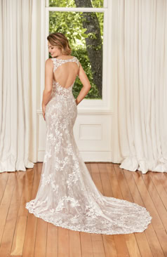 Ein elegantes Brautkleid im Fit and Flare Stil mit wunderschönen perlenbesetzten Muschel-Spitzenapplikationen, die sich im ganzen Kleid wiederfinden. Das Kleid schmeichelt den Bereich der Taille, durch Stretch- Jersey für eine kurvenliebende Silhouette. Die zarte Muschelspitze schmückt die schmalen Schulterträger und den V- Ausschnitt des Brautkleides. Die Spitze verläuft sanft den Rock bis zur Schleppe hinunter zu einem Spitzenfinish. Zu schließen ist das Kleid mit einem Reißverschluss und Knöpfen.