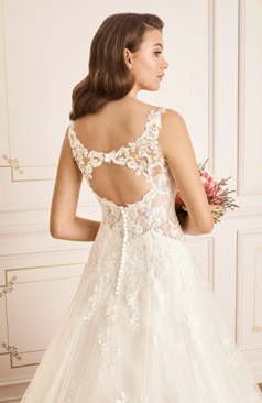 Ein zeitlos, klassisches und romantisches Hochzeitskleid im Stil einer A-Linie. Die glitzernde A- Linie hat einen tiefen V- Ausschnitt, der durch zarte Spitzenträger und einen eleganten Schlüsselloch Rücken vervollständigt wird. Das gesamte Oberteil ist mit Paillettenapplikationen und Spitze verziert, die an dem Rock filigran hinunterlaufen. Die Taille wird durch schmeichelhafte Seitenausschnitte betont. Das Kleid verfügt über eine wundervolle Schleppe die aus Glitzertüll gefertigt wurde. Der halbtransparente Rücken lässt sich durch eine Knopfleiste schließen. 