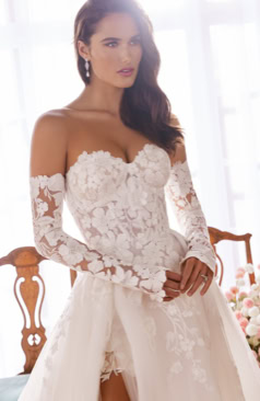 A-Linie Brautkleid mit abnehmbarem Überrock, figurbetonter Spitzen-Corsage und langen Spitzenärmeln, kombiniert mit modernem Schlitz – FM Braut- und Abendmode Sandkrug bei Oldenburg.