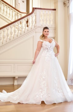 Ein wunderschönes Hochzeitskleid im A-Linien Stil. Das Kleid besitzt leichte Flügelärmel aus Spitze und einen romantischen Illusionsrücken mit Spitzen- Verzierungen. Im Bereich des Rückens wird das Kleid durch eine Knopfleiste geschlossen. Zugleich verfügt das Kleid über eine edle Schleppe und Rosshaarsaum. Markante Spitzenapplikationen verteilen sich im Oberteil des Kleides und im unteren Bereich des Rockes. 