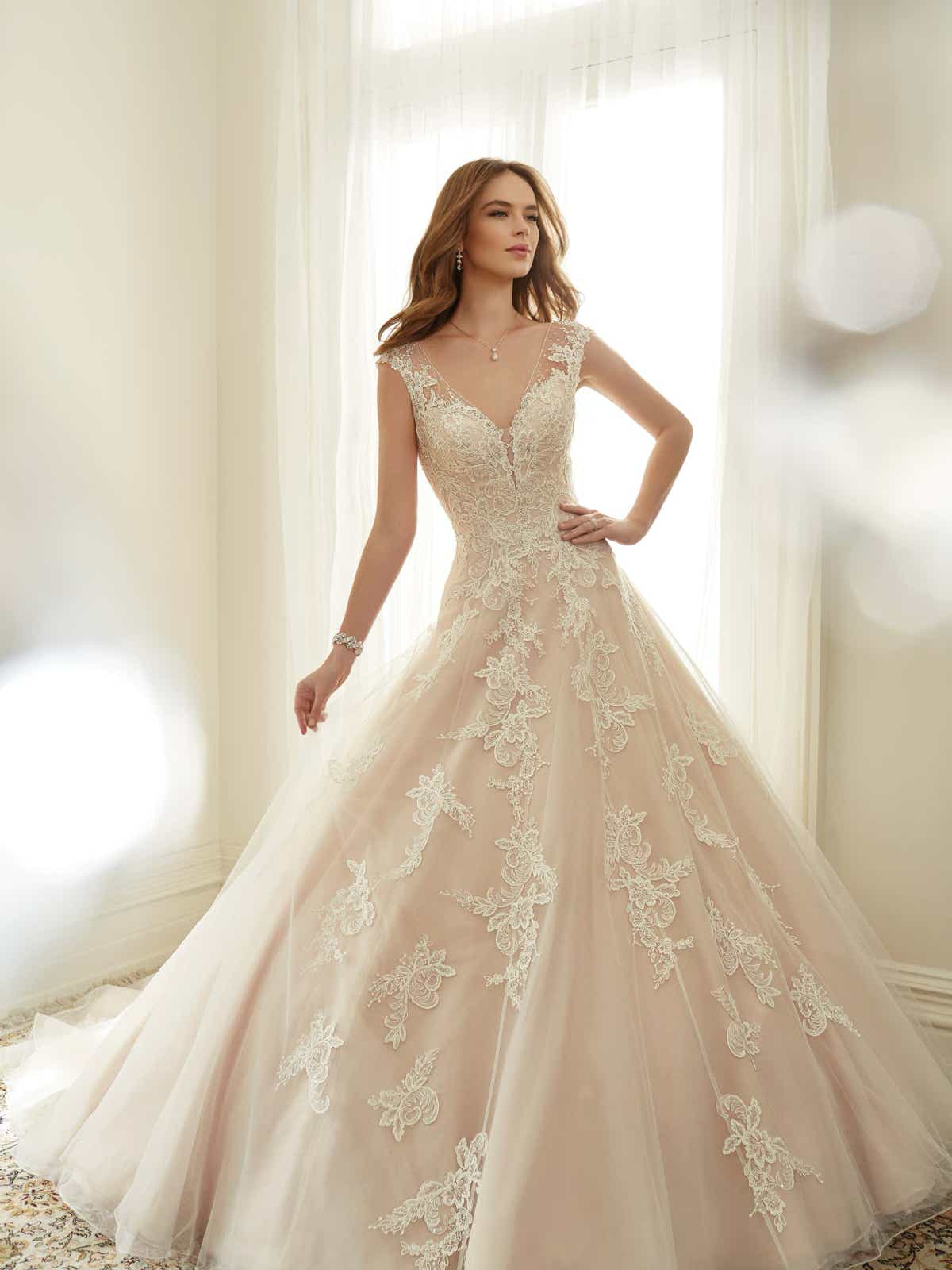 50974 Romantisch-Schön! Das zusehende Brautkleid verfügt über einen verführerischen herzförmigen V- Ausschnitt, elegante Illusionsspitzen-Träger, einen himmlischen Tüllrock und exklusive und gleichzeitig moderne Spitzenapplikationen. Die Silhouette wird hervorgehoben, durch die schmeichelnde A-Linie. Geschlossen wird das Brautkleid mithilfe einer bezaubernden Schnürung. Außerdem wird das Kleid durch den fantastischen Rückenausschnitt und der atemberaubenden Schleppe vervollständigt.