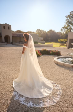 A-Linie Brautkleid mit eleganter Off-Shoulder-Ausschnittlinie, langer Schleppe und durchgehender Knopfleiste im Rücken – FM Braut- und Abendmode Sandkrug bei Oldenburg.