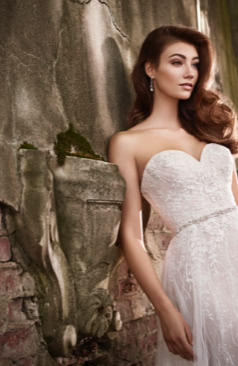 19456 Allover- Spitze, geraffter Tüll und funkelnde Pailletten. Ein wunderschönes leichtes und gleichzeitig verspielte Hochzeitskleid im A- Linien Stil. Der wiederum herzförmige Ausschnitt schmeichelt dem Dekolleté. Die Spitze und die glänzenden Fadenapplikationen verstärken das Strahlen des Kleides. Zudem verfügt das Kleid über einen schönen Corsage, die durch eine Schnürung geschlossen wird. Zusätzlich besitzt das Hochzeitskleid abnehmbare Träger und eine romantische Schleppe.