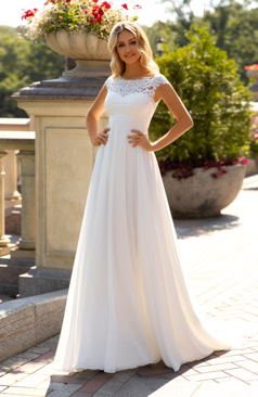 Boho-Brautkleid mit einem modernen Touch. Das Oberteil ist mit Pailletten besetzter Spitze verziert und mit einem leichten Chiffonrock kombiniert.