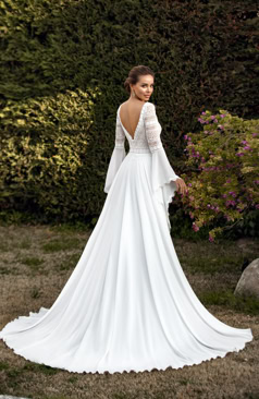 Brautkleid im Boho-Stil mit zarter Spitze, einem tiefen Ausschnitt und fließenden langen Spitzen/Chiffon Ärmeln. 