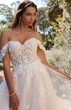 A-Linien Brautkleid mit abnehmbaren Off-Shoulder-Trägern, floraler Spitze und ausgedehnter Schleppe in eleganter Gartenkulisse – FM Braut- und Abendmode Sandkrug bei Oldenburg.