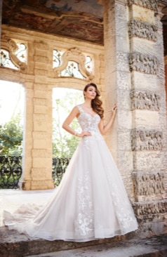Ein wunderschönes Hochzeitskleid im A-Linien Stil. Das Kleid besitzt leichte Flügelärmel aus Spitze und einen romantischen Illusionsrücken mit Spitzen- Verzierungen. Im Bereich des Rückens wird das Kleid durch eine Knopfleiste geschlossen. Zugleich verfügt das Kleid über eine edle Schleppe und Rosshaarsaum. Markante Spitzenapplikationen verteilen sich im Oberteil des Kleides und im unteren Bereich des Rockes. 