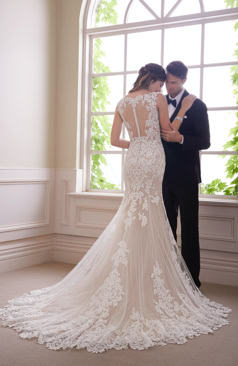 Ein wundervolles Fit and Flare Brautkleid mit markanter Spitze verziert. Das Brautkleid hat einen eleganten V- Ausschnitt sowie einen tief geschnittenen Rücken aus Tattoo-Spitze. An dem verführerischen Rücken befindet sich eine Knopfleiste. Das Fit and Flair Brautkleid hat zugleich elegante Beinschlitze an den Seiten des Kleides und eine stilvolle Tüll-Schleppe. 